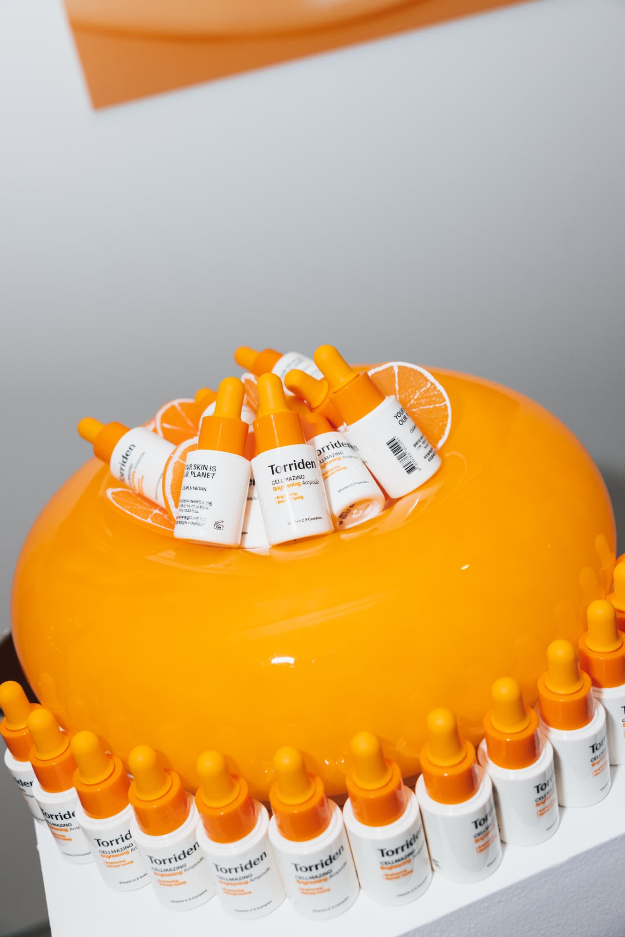Torriden Cellmazing ampoules styled on an oversized orange installation at the Torriden NYC pop-up