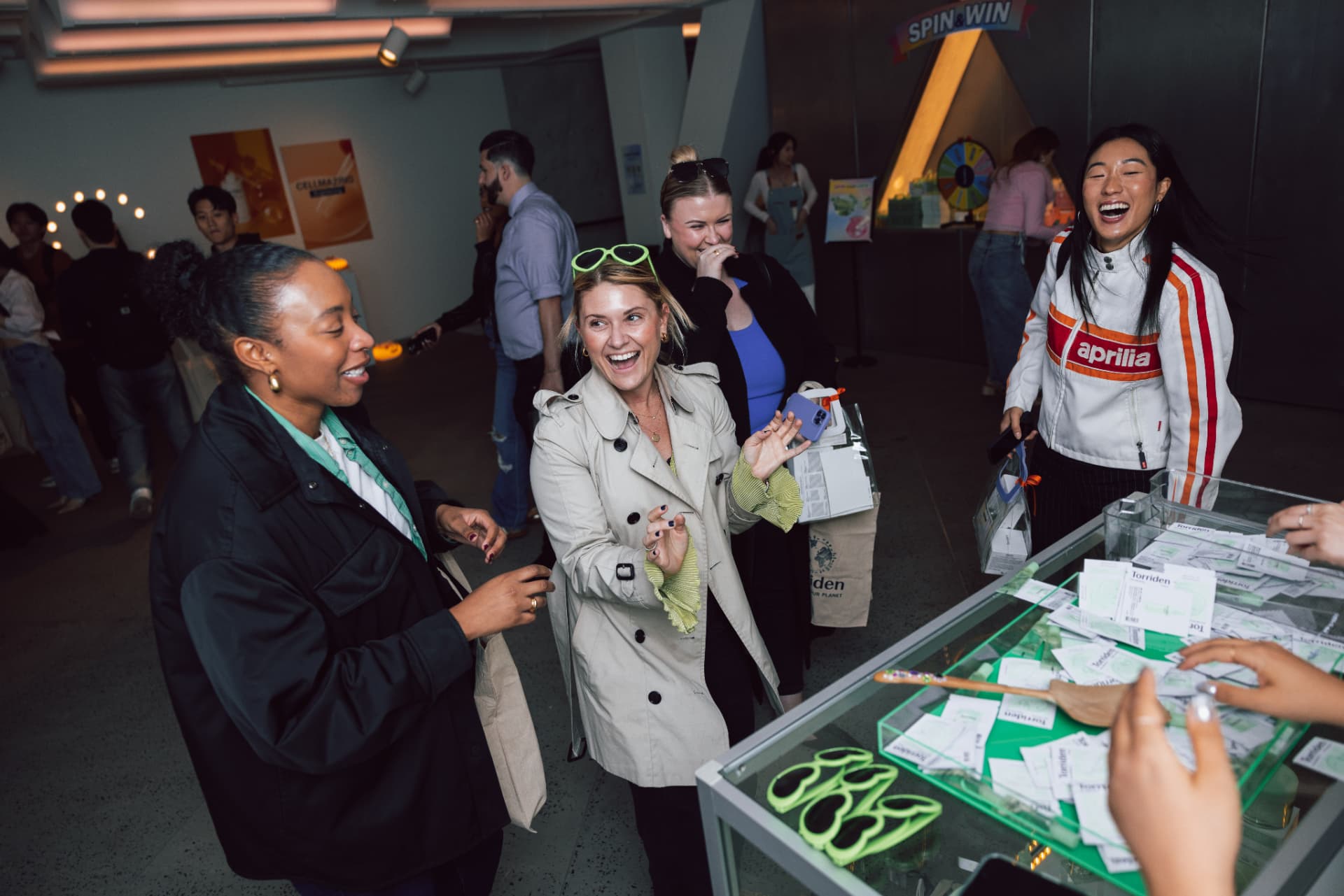 Guests laughing at the Spin & Win prize station inside the Torriden New York pop-up