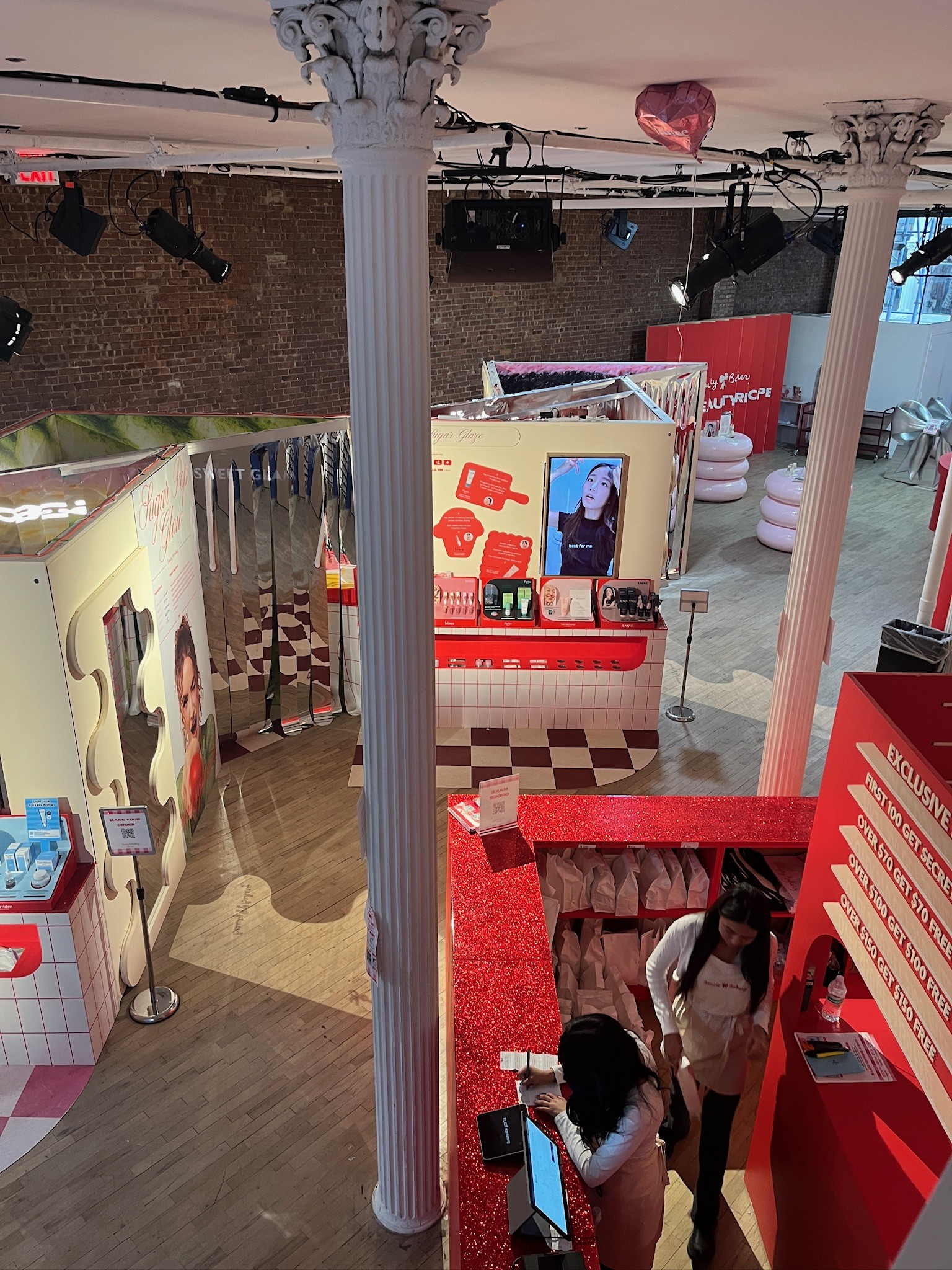 Overhead view of the Beauty Bakery pop-up showing the recipe stations, product displays, and staff